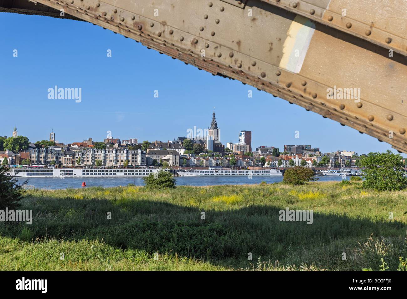 La città vecchia di Nijmegen e il fiume Waal, incorniciata dalla trave arrugginita del ponte Waalbrug. Foto Stock