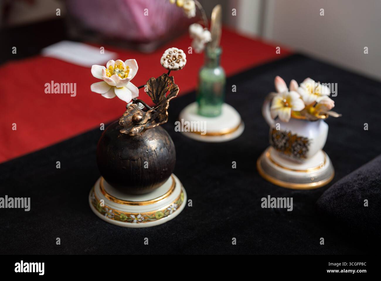 Una sofisticata disposizione floreale caratterizzata da delicati fiori in vasi decorativi in ceramica. la scena trasuda eleganza e stile artistico, perfetto per Foto Stock