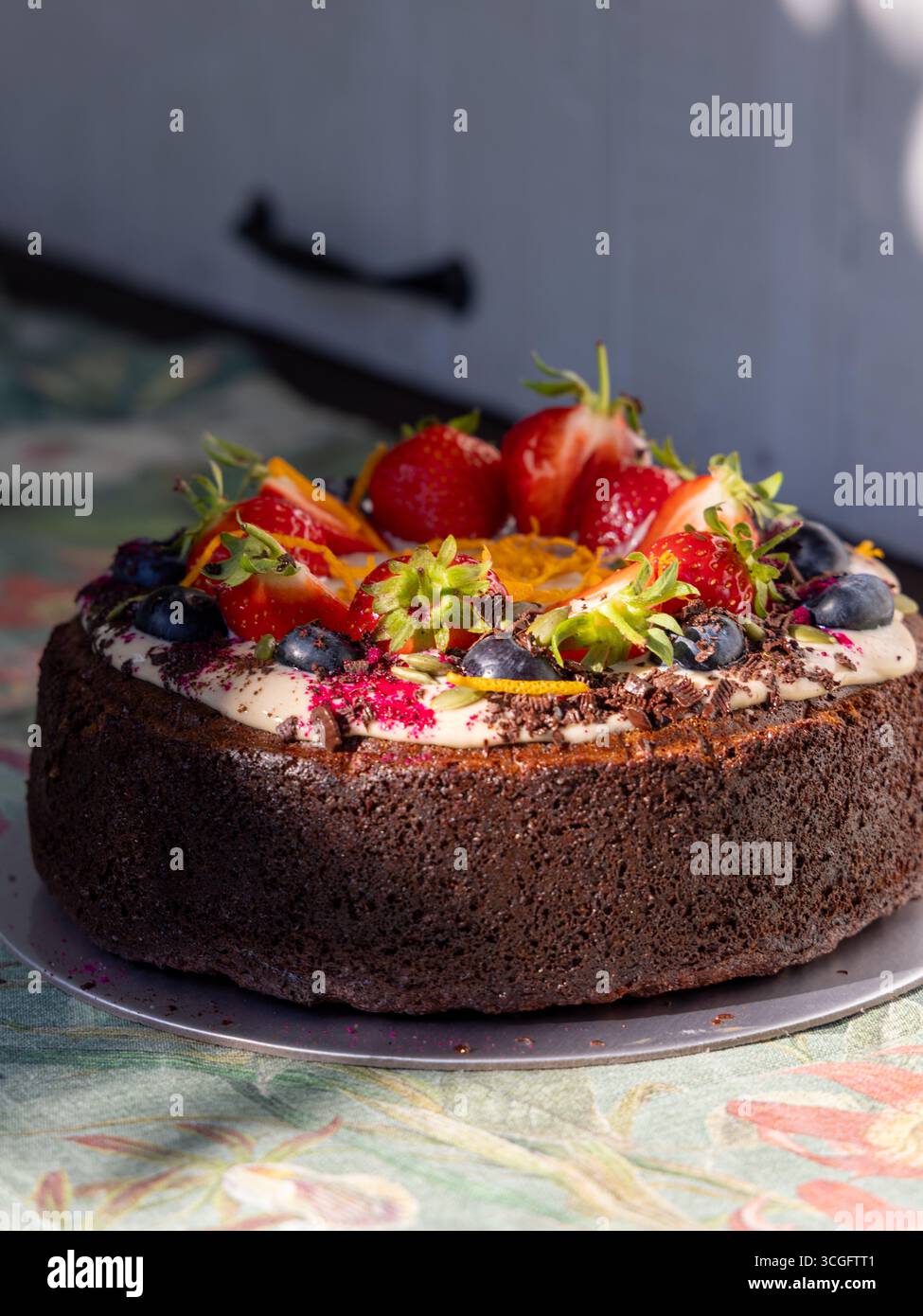 Torta di carote ricoperta di fragole, mirtilli, fette d'arancia, guarnizione a foglia e spruzzi rossi. Una sana ricetta Zoe-friendly di Tim Spector. Foto Stock Torta di carote ricoperta di fragole, mirtilli, fette d'arancia, guarnizione a foglia e spruzzi rossi. Una sana ricetta Zoe-friendly di Tim Spector. Foto Stock