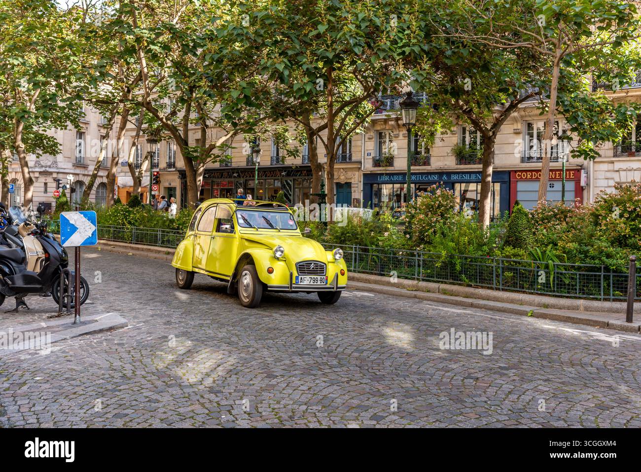 Parigi, Francia, 08.25.2025. Una Citroën 2CV gialla con turisti che guidano attraverso rue de l'Estrapade, dove è stata girata la serie Netflix "Emily in Paris" Foto Stock