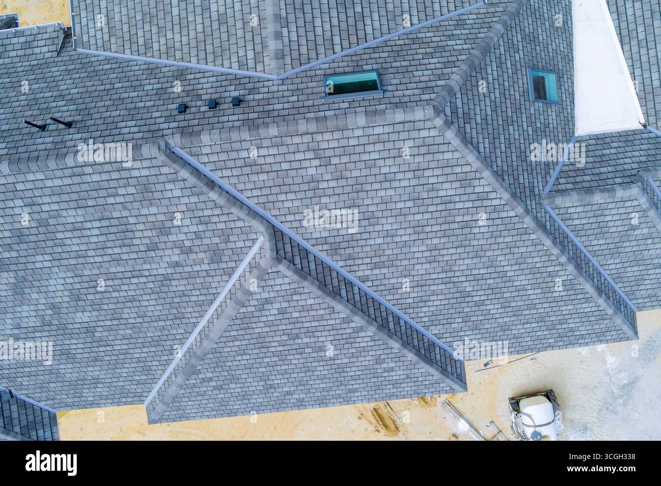 Vista dall'alto della casa di recente costruzione con tetto in ardesia grigio, materiali da costruzione esposti durante il giorno dei lavori Foto Stock