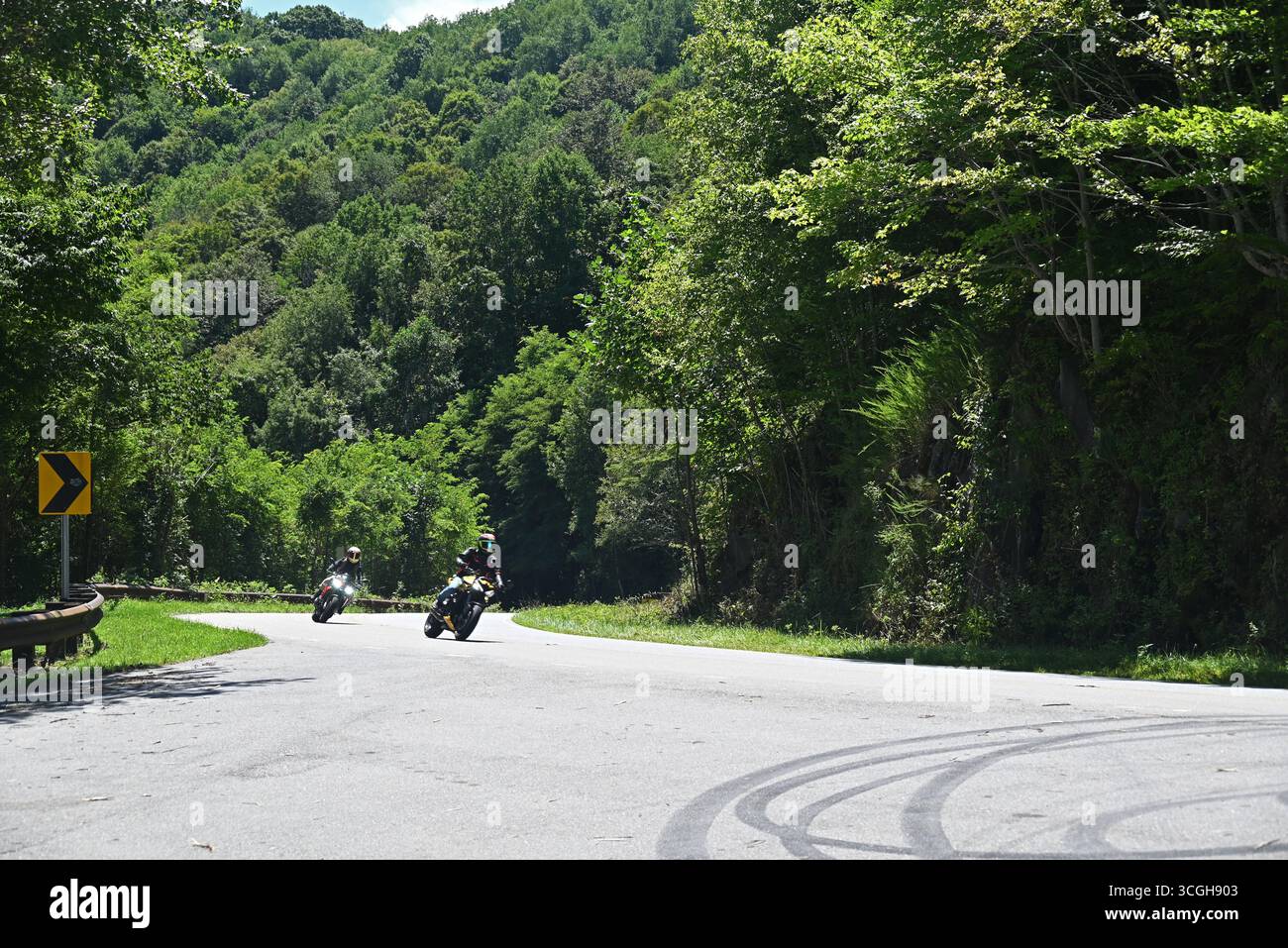 Un paio di motociclette si appoggiano su una curva mentre guidano sulla Cherohala Skyway sul confine tra Tennessee e Carolina del Nord Foto Stock