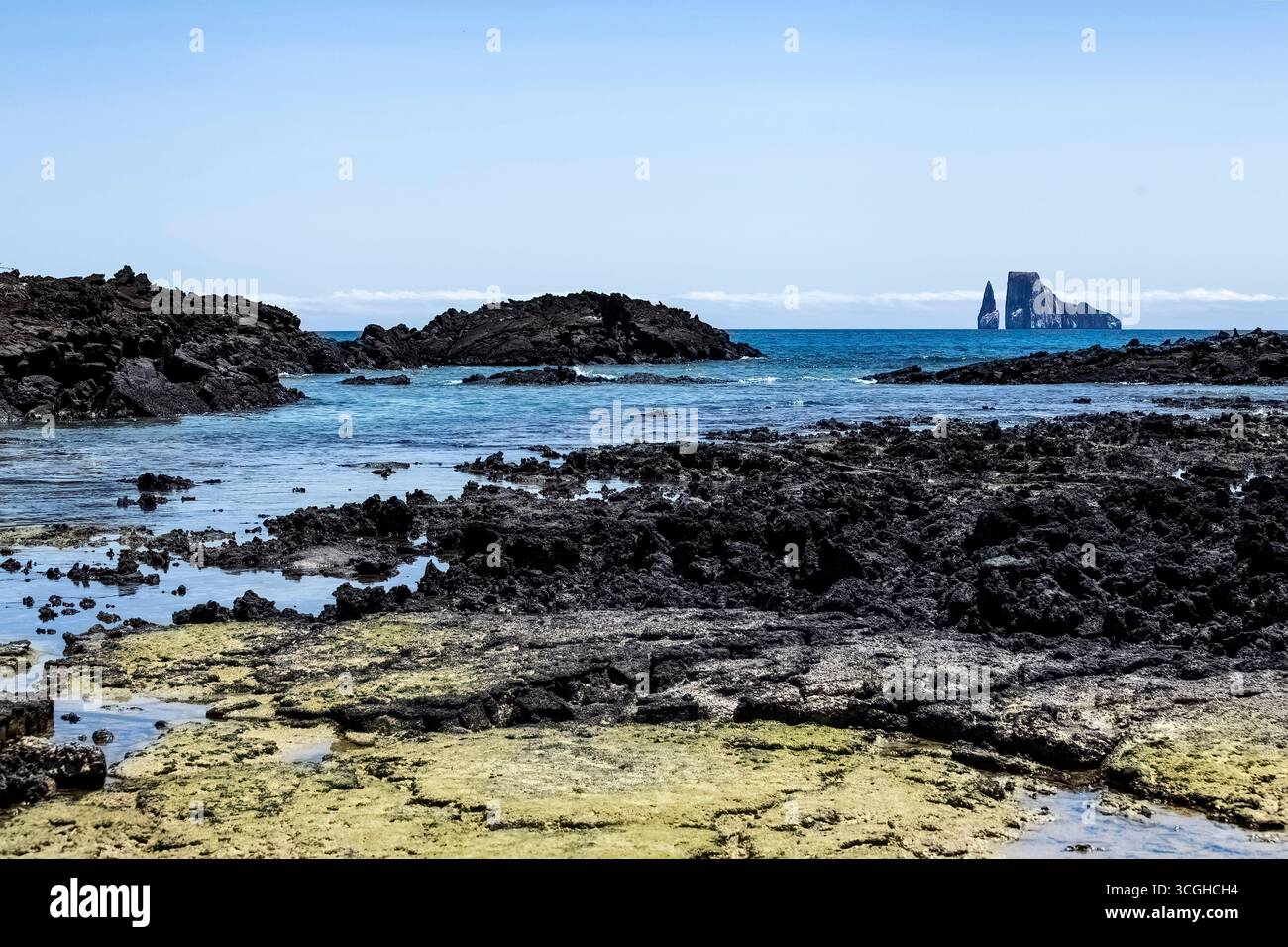 Vista panoramica di una spiaggia sull'isola di San Cristóbal, Galápagos, Ecuador, con la famosa formazione rocciosa Kicker Rock (León Dormido) sullo sfondo. Foto Stock
