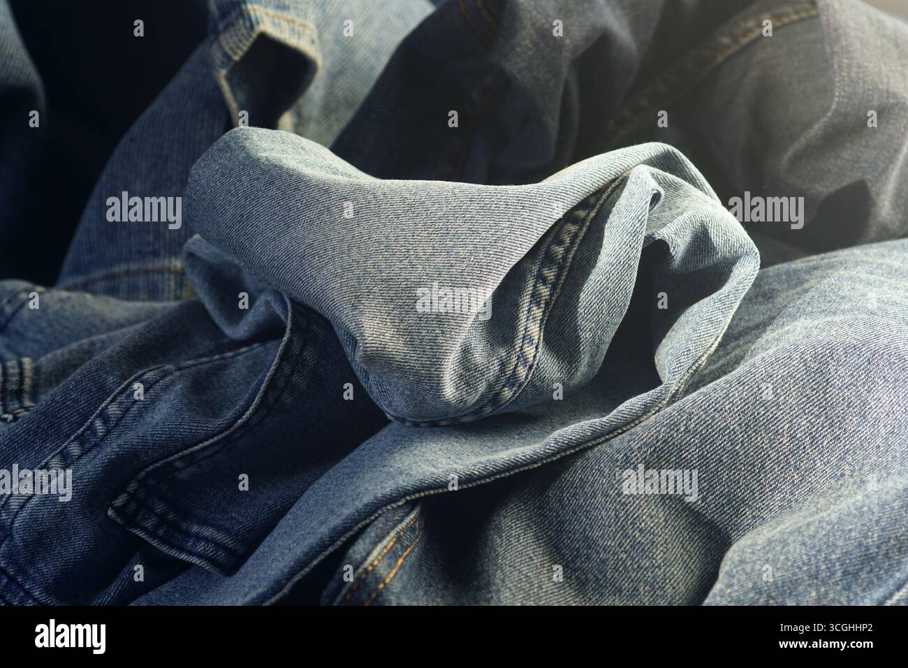 Primo piano su fondo jeans in denim. Materiale moda sostenibile. Upcycling eco-compatibile, stile di vita senza sprechi, moda lenta, abbigliamento etico Foto Stock