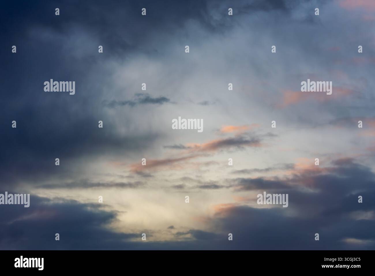 Cielo serale con nuvole di tempesta e luce colorata al tramonto, che mostra toni caldi e freddi. Foto Stock