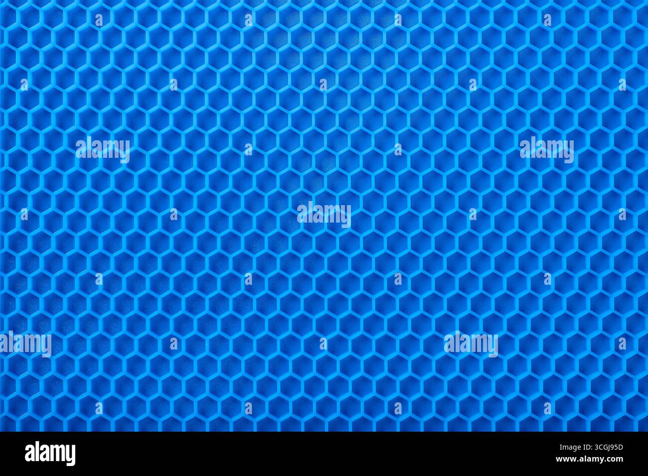 sottobicchiere resistente al calore in silicone blu con motivo a nido d'ape come sfondo e texture Foto Stock