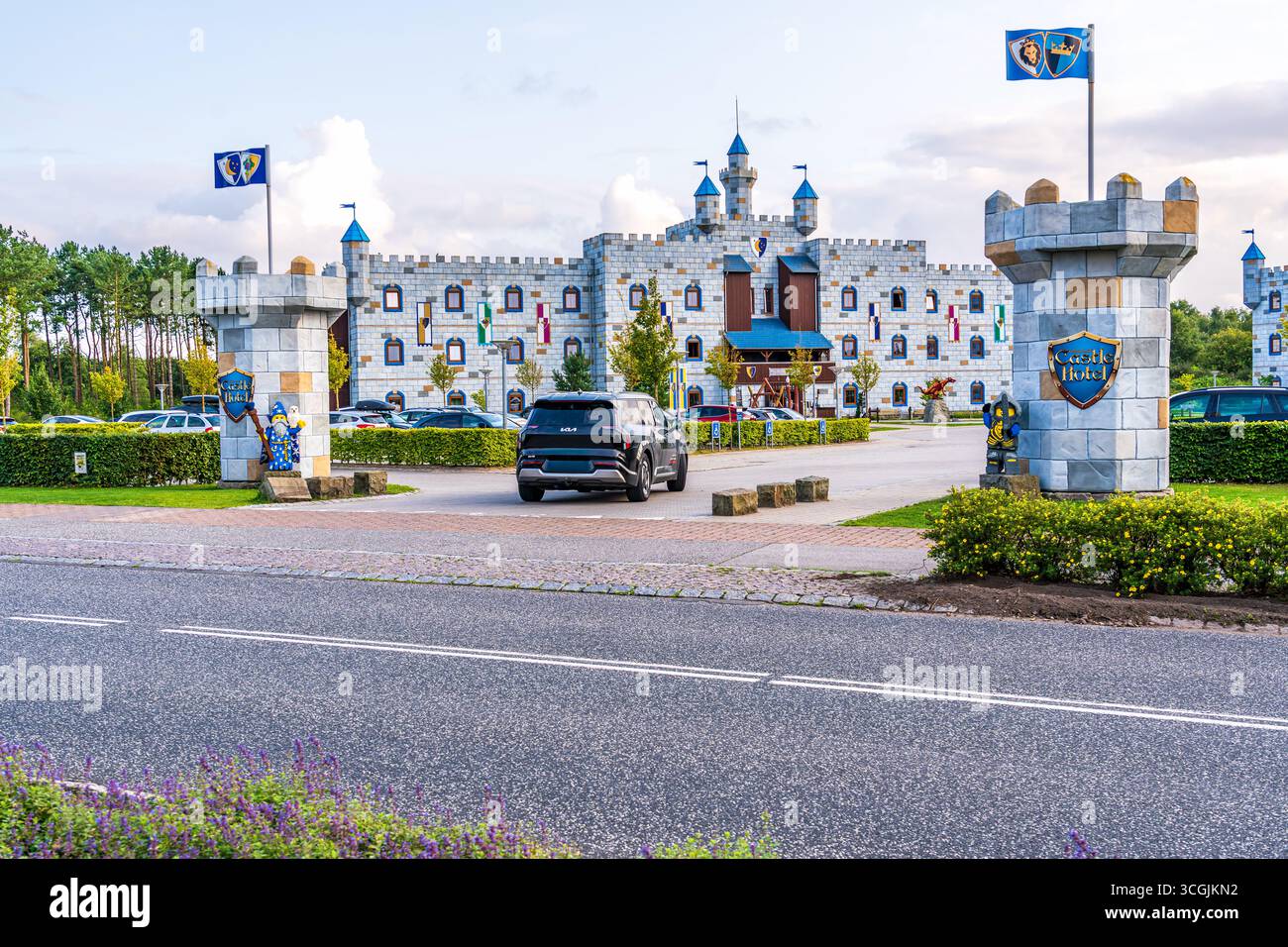 L'auto entra nel vialetto all'ingresso di Legoland del Wizards and Knights Castle Hotel, le colorate figure Lego accolgono gli ospiti nelle calde serate estive Foto Stock