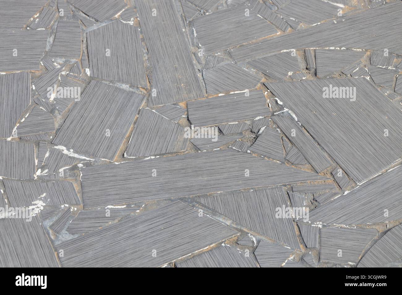 Sfondo a struttura astratta con cornice completa di una superficie rustica del patio composta da grandi piastrelle di ceramica rotte in stile mosaico Foto Stock