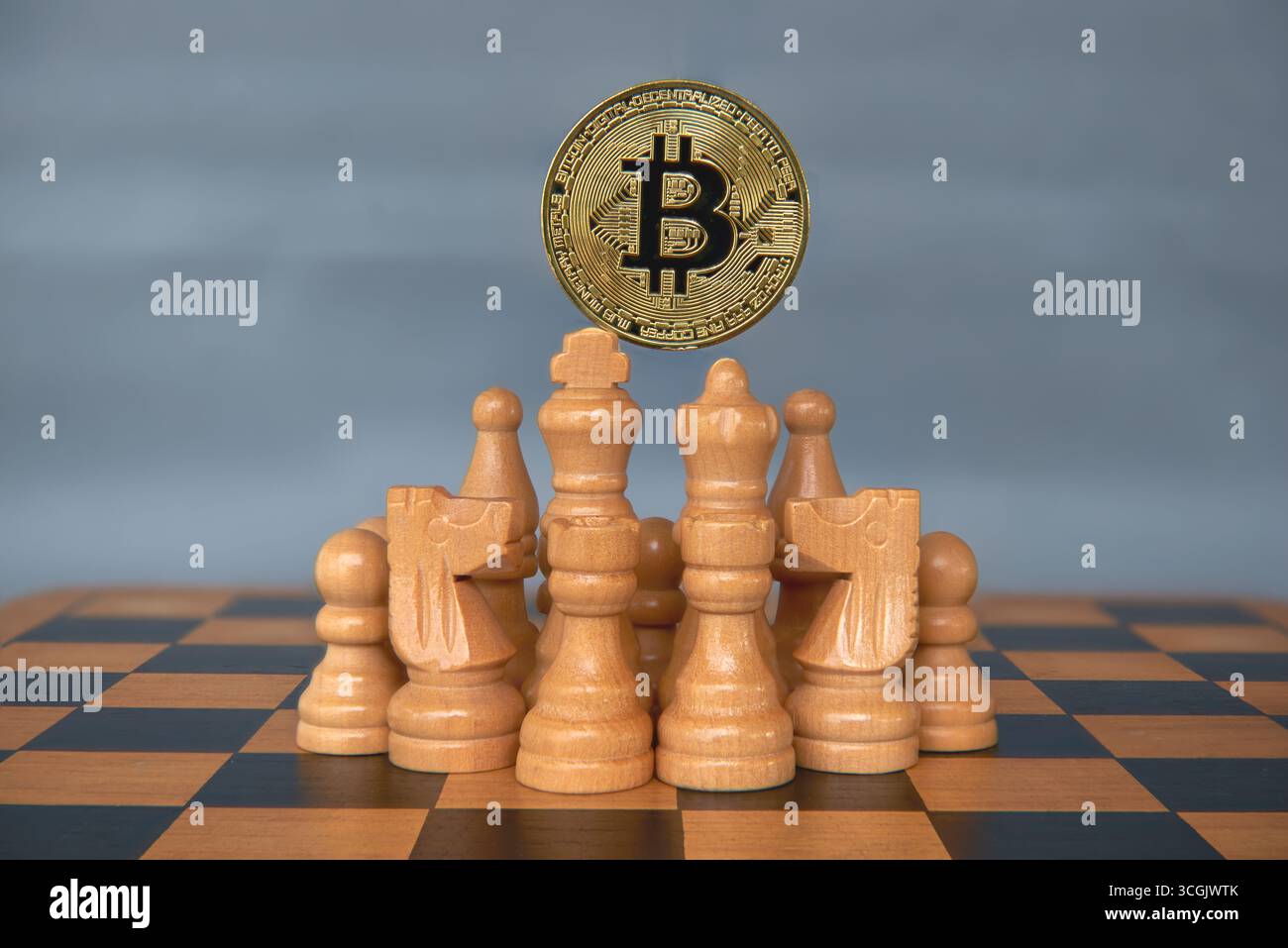 Un Bitcoin fisico che porta altri pezzi di scacchi su una scacchiera. Una potente immagine concettuale per la strategia finanziaria, la leadership nelle criptovalute, il mercato c Foto Stock