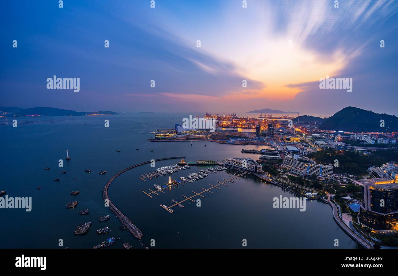 {'réponse': {'statut': 'Success', 'message': 'Shenzhen China Waterfront si illumina al tramonto con le barche attraccate e le luci della città scintillanti.'},} Foto Stock