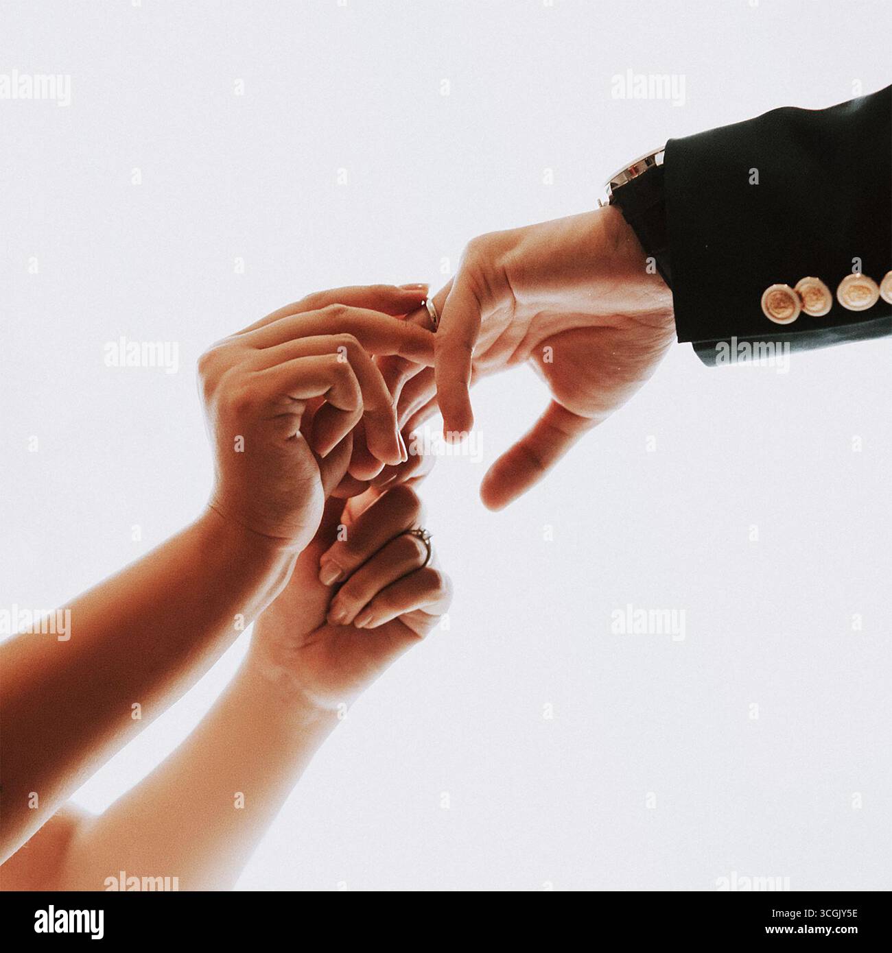 Anelli per lo scambio di mani da sposa e sposo su sfondo bianco minimale Foto Stock