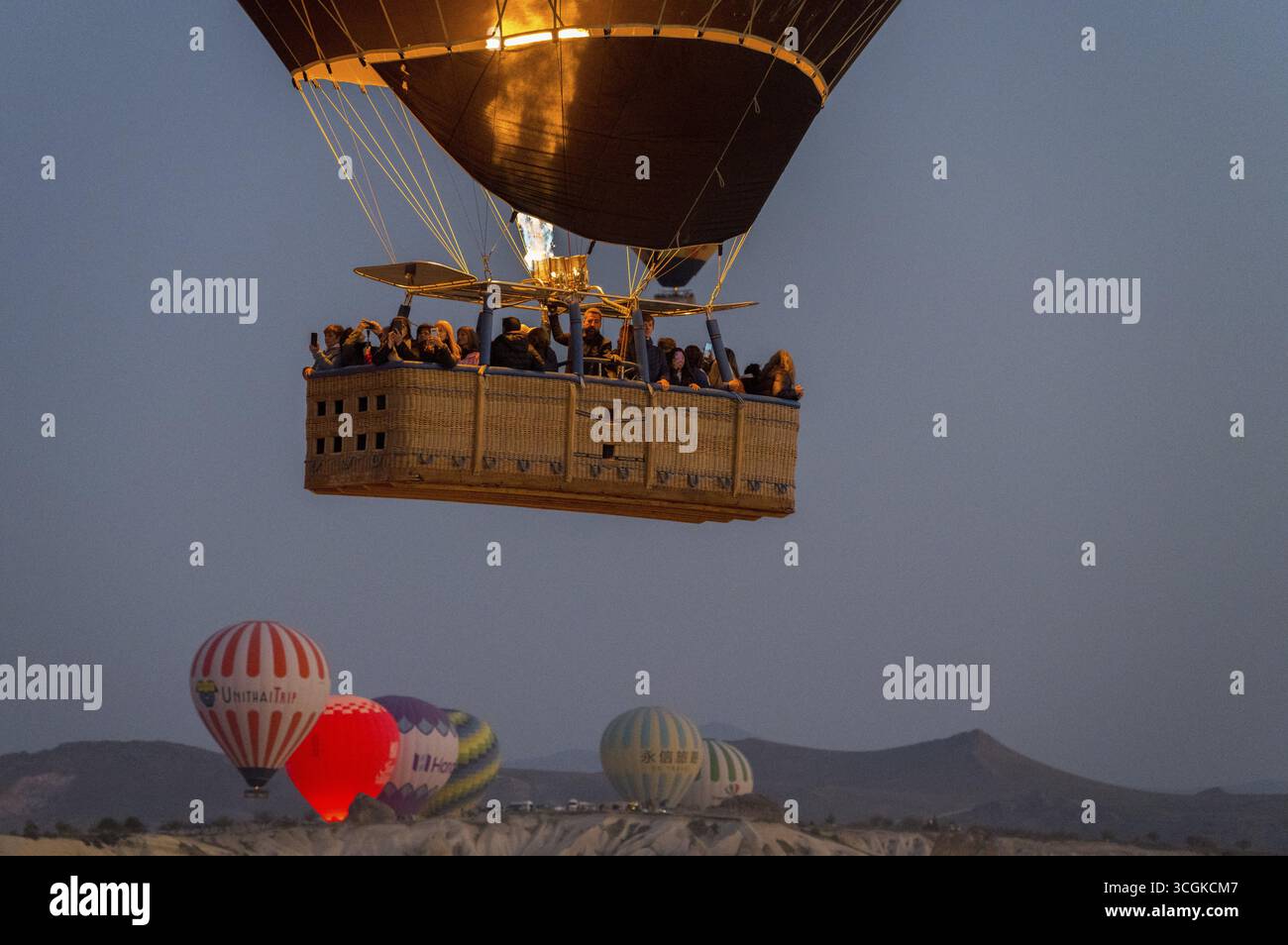 Una mongolfiera con passeggeri nel cesto galleggia sotto il cielo mattutino, il Parco Nazionale di Goereme, il Parco Nazionale di Goereme Tarihi Milli ParkIJ, la Provincia di Nevsehir Foto Stock