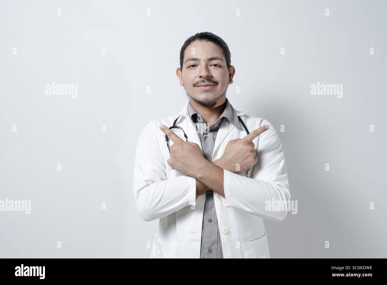 Giovane medico che punta su entrambi i lati su isolato Foto Stock