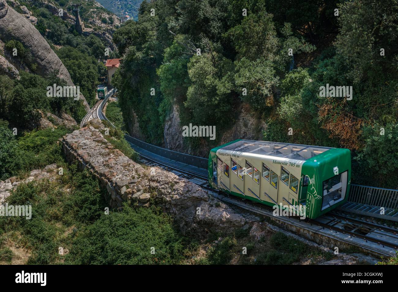 Funicolare Santa cova che sale attraverso Montserrat con antiche mura di pietra. Trasporto ferroviario di montagna, infrastrutture storiche, Grotta Sacra Foto Stock
