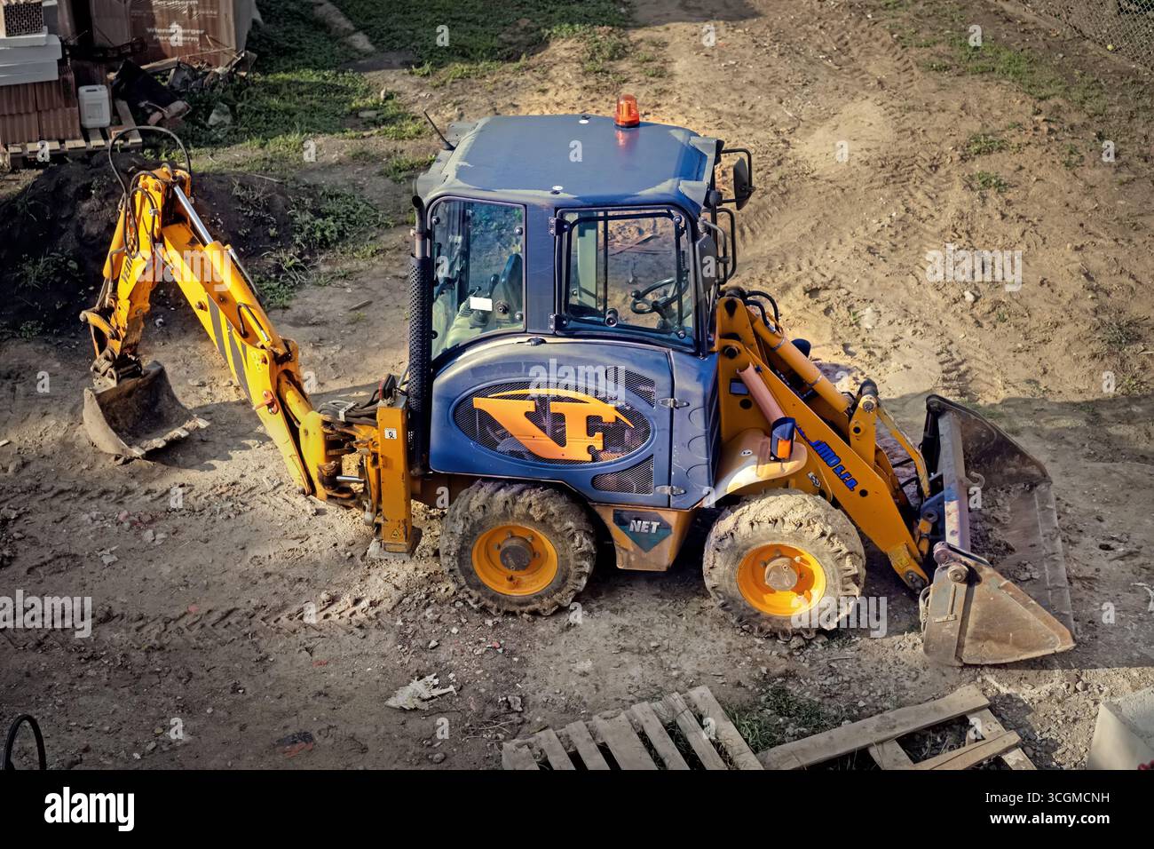 Escavatore giallo al sito in costruzione Foto Stock