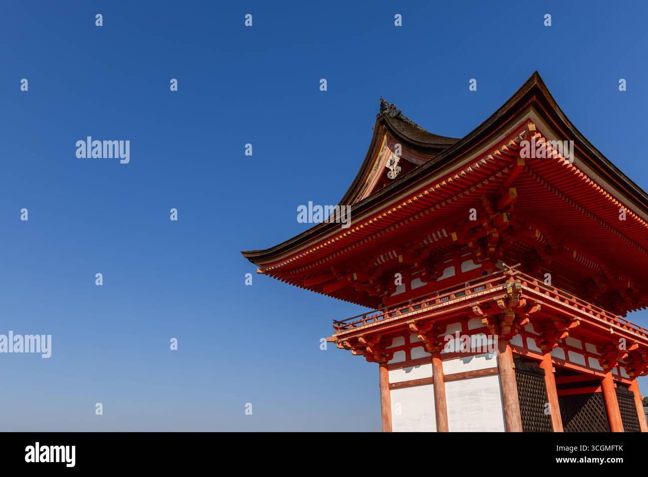 Composizione minimalista della porta di Niomon a Kiyomizu-dera a Kyoto, Giappone, caratterizzata da un'architettura in legno rosso sotto un cielo azzurro limpido con linee pulite e così via Foto Stock