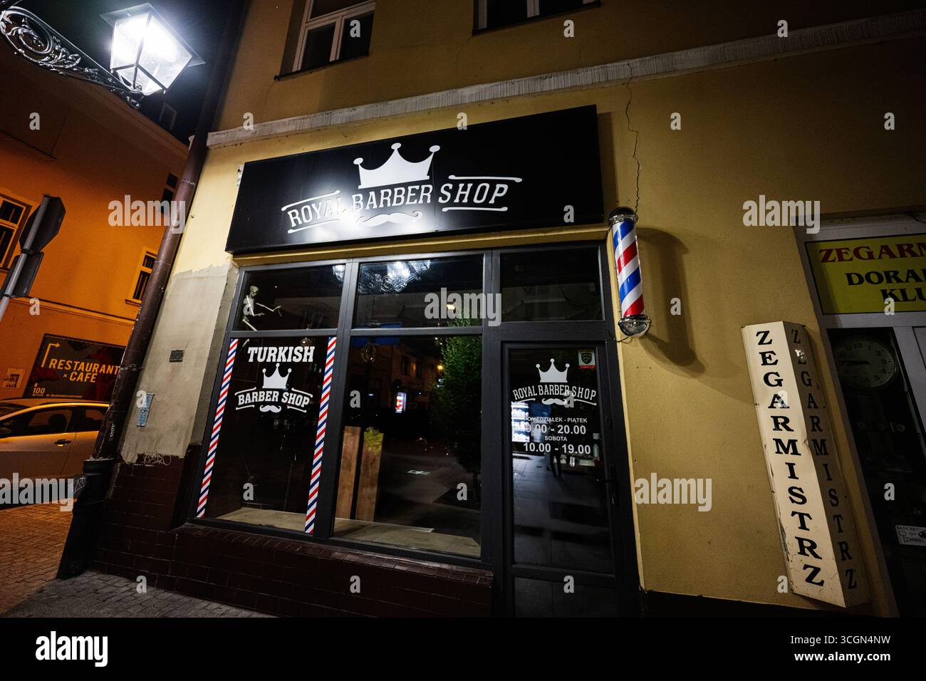 Rzeszow, Polonia - 22 agosto 2025: Negozio di barbiere reale di notte situato a Rzeszow, Polonia, che presenta uno stile classico. Foto Stock