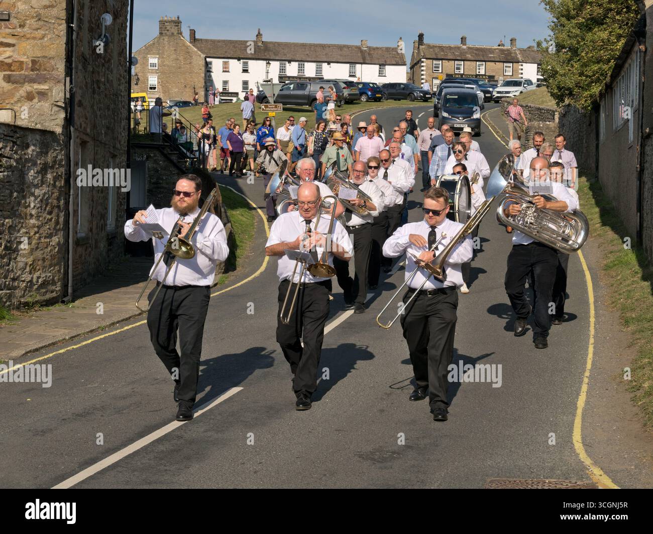 La Reeth Brass Band marcerà attraverso il villaggio sulla strada per il Reeth Show, North Yorkshire Foto Stock