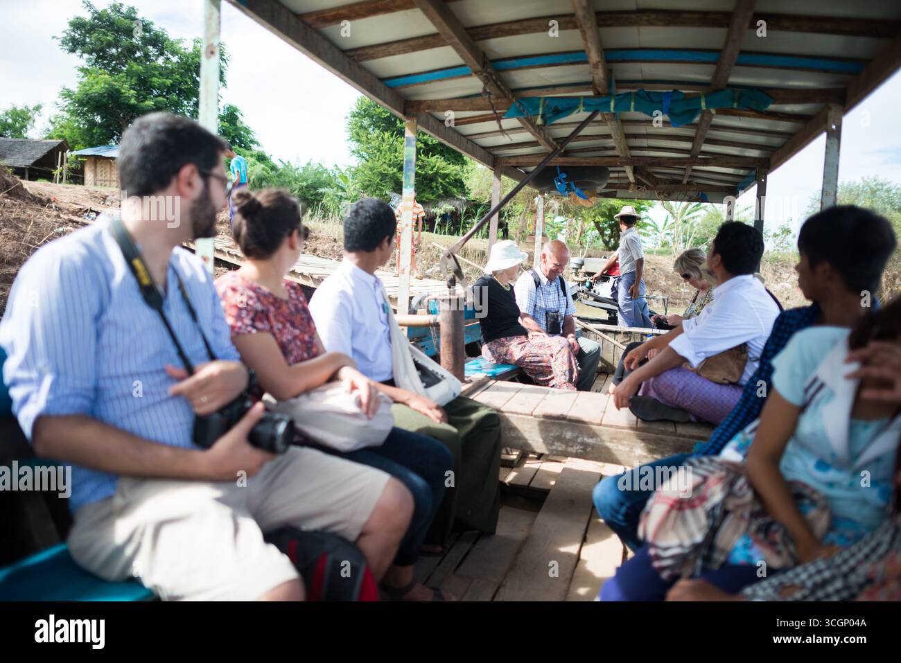 Passeggeri del traghetto sul fiume Myitnge Amarapura Myanmar // AMARAPURA, Myanmar - i passeggeri sono a bordo di un traghetto che attraversa il fiume Myitnge ad Amarapura, regione di Sagaing. Il fiume Myitnge è un importante affluente del fiume Ayeyarwady (noto anche come Irrawaddy River), che funge da canale vitale per i trasporti e il commercio. Questo servizio di traghetto fornisce collegamenti essenziali per i residenti locali e i visitatori che viaggiano all'interno della regione. Amarapura, una storica ex capitale reale, si trova vicino a Mandalay in Myanmar (Birmania) ed è rinomata per il suo patrimonio culturale. La regione di Sagaing è un'amministrazione amministrativa Foto Stock
