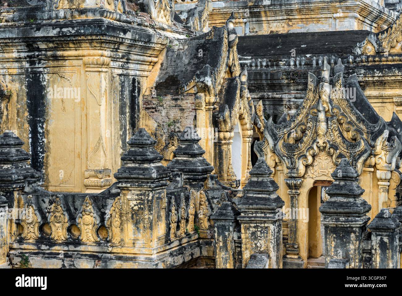 Monastero di Maha Aungmye Bonzan Dettagli ornati di stucco Amarapura Myanmar // AMARAPURA, Myanmar — dettagli decorati in stucco adornano l'esterno del monastero di Maha Aungmye Bonzan, un significativo sito buddista ad Amarapura. Questo monastero dell'era Konbaung, costruito in mattoni e stucchi, è rinomato per imitare in modo unico i tradizionali monasteri in legno utilizzando materiali più durevoli. La regina Nanmadaw me Nu, capo regina del re Bagyidaw, ne commissionò la costruzione nel 1818 per l'abate reale Nyaunggan Sayadaw U Pok. Il monastero è stato restaurato nel 1873 a seguito di un terremoto. Il monastero di Maha Aungmye Bonzan è Foto Stock