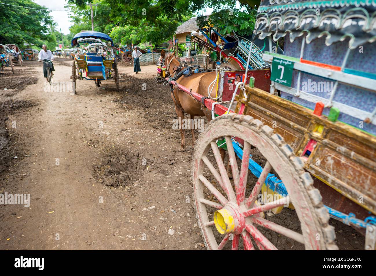 Gite turistiche a cavallo e in carrozza Inwa Amarapura Myanmar // INWA (anche conosciuta come Ava), Amarapura, Myanmar - le giostre turistiche a cavallo e in carrozza sono un mezzo di trasporto primario per i visitatori che esplorano l'antica città. Queste tradizionali carrozze trainate da cavalli percorrono le strade sterrate della zona. Sono il modo principale per i turisti di muoversi perché non ci sono taxi o auto ammessi nella zona. Inwa, un'ex capitale reale, si trova vicino ad Amarapura nella regione di Sagaing nel Myanmar centrale (nota anche come Birmania). La zona è una destinazione popolare per le sue rovine storiche e il fascino rurale, Foto Stock