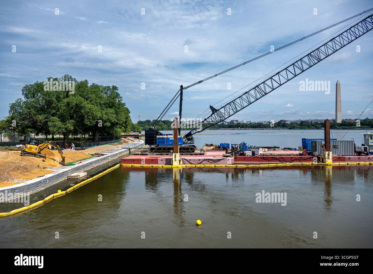 Tidal Basin Seawall Reconstruction Project Crane Barge Washington Monument Washington DC // WASHINGTON DC - il Tidal Basin Seawall Reconstruction Project è stato visto il 14 agosto 2025, con una chiatta con gru e la costruzione in corso del nuovo Seawall. Questa iniziativa pluriennale del National Park Service ha lo scopo di riparare e innalzare le dighe che si deteriorano intorno al bacino delle maree, affrontando il cedimento e le frequenti inondazioni. Il progetto è fondamentale per proteggere memoriali iconici come il Jefferson Memorial e il Franklin Delano Roosevelt Memorial. Sullo sfondo, il Washington Monument, sta Foto Stock