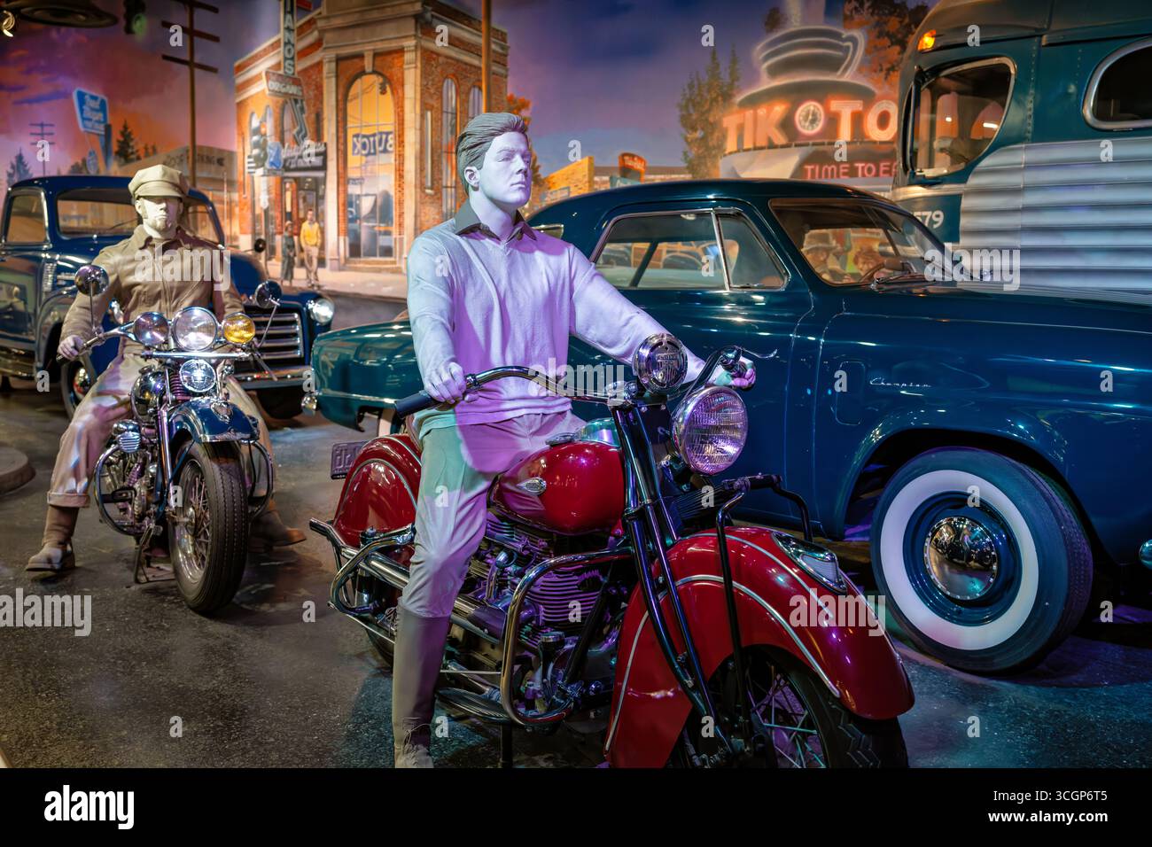 Indian Motorcycle 1941 Suburban Strip Exhibit National Museum of American History Washington DC | WASHINGTON D.C., Stati Uniti — Una motocicletta indiana del 1941, con i suoi distintivi parafanghi con bordo, fissa la "Suburban Strip: Sandy Boulevard, Portland, Oregon, 1949" al National Museum of American History. La Indian Motorcycle Company, fondata nel 1901, ha visto il picco delle vendite civili nel 1940 e nel 1941 prima che la seconda guerra mondiale interrompesse la produzione per uso militare. Il diorama ricrea una striscia commerciale americana del dopoguerra con veicoli d'epoca e vetrine. Foto Stock