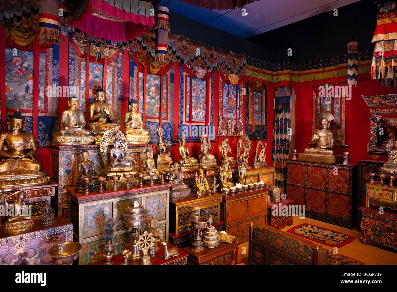 Smithsonian National Museum of Asian Art sala del santuario tibetano Washington DC USA // WASHINGTON DC - la sala del santuario tibetano presso il Museo Nazionale d'Arte Asiatica dello Smithsonian presenta una serie di statue di Buddha dorate e oggetti rituali tradizionali. Questa installazione permanente ricrea un tradizionale santuario buddista tibetano, offrendo un'esperienza coinvolgente. Adornata con thangka e tessuti colorati, la sala fa parte della Freer Gallery of Art e della Arthur M. Sackler Gallery. Collettivamente formando il museo, questa mostra è stata inaugurata nel 2001. Si trova sul National Mall. Foto Stock