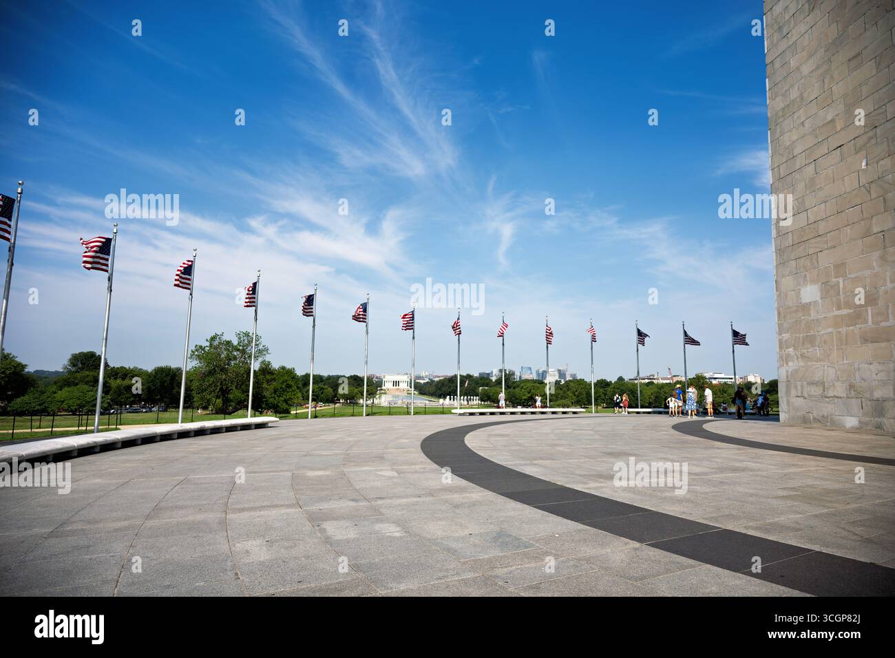 Monumento a Washington Fifty American Flags National Mall Lincoln Memorial View Washington DC // WASHINGTON DC - cinquanta bandiere americane circondano la base del monumento a Washington sul National Mall, con il Lincoln Memorial visibile in lontananza. Questo iconico obelisco onora il primo presidente degli Stati Uniti, George Washington, ed è un punto di riferimento importante nella capitale della nazione. Costruito in marmo, granito e gneiss di pietra blu, il monumento è alto 555 piedi 1/8 pollici (169,29 metri), il che lo rende l'obelisco più alto del mondo. Completato nel 1884, è una caratteristica chiave del National Mall e della memoria Foto Stock