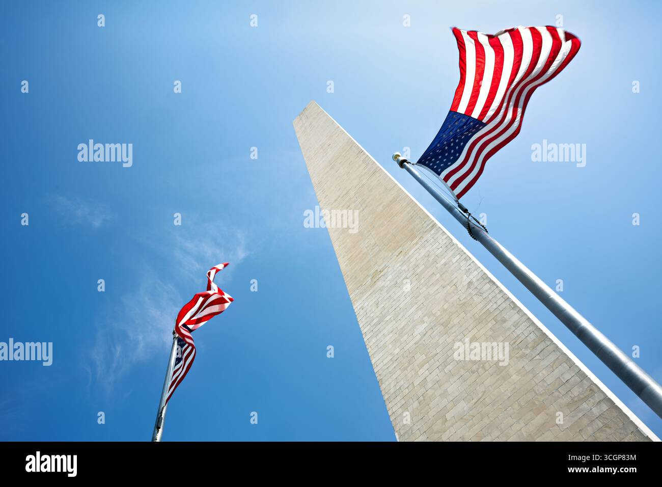 Monumento a Washington con le bandiere americane Blue Sky Washington DC Stati Uniti // WASHINGTON DC - le bandiere americane ondeggiano vicino alla base del monumento a Washington, un importante punto di riferimento sul National Mall. Questo iconico obelisco è un memoriale a George Washington, il primo presidente degli Stati Uniti. Con un'altezza di 169,29 metri (555 piedi), era la struttura più alta del mondo al suo completamento nel 1884. Un anello di 50 bandiere americane, che rappresentano ogni stato degli Stati Uniti, in genere circonda il monumento. Costruito in marmo, granito e gneiss di pietra blu, il monumento è gestito dal National Foto Stock