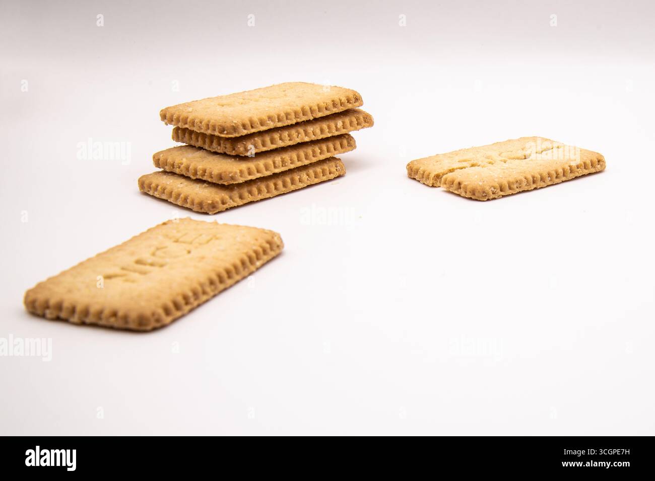 Selezione di deliziosi biscotti dorati disposti su uno sfondo bianco pulito, ideali per cibo, snack, dessert, dolciumi, e concetti di cottura. Foto Stock