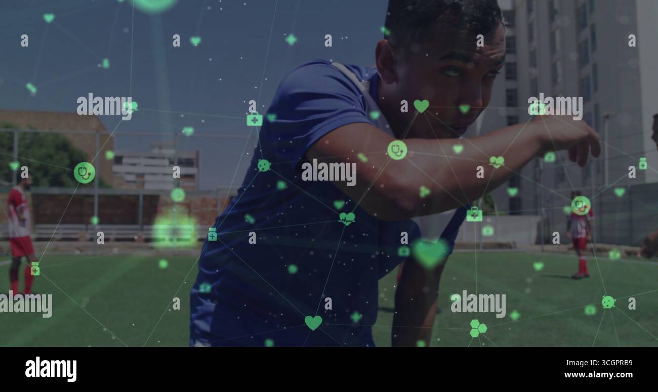 Dabbing sudore dal viso giocatore di calcio maschile sul campo di erba urbana, con icone di salute digitali sovrapposte Foto Stock