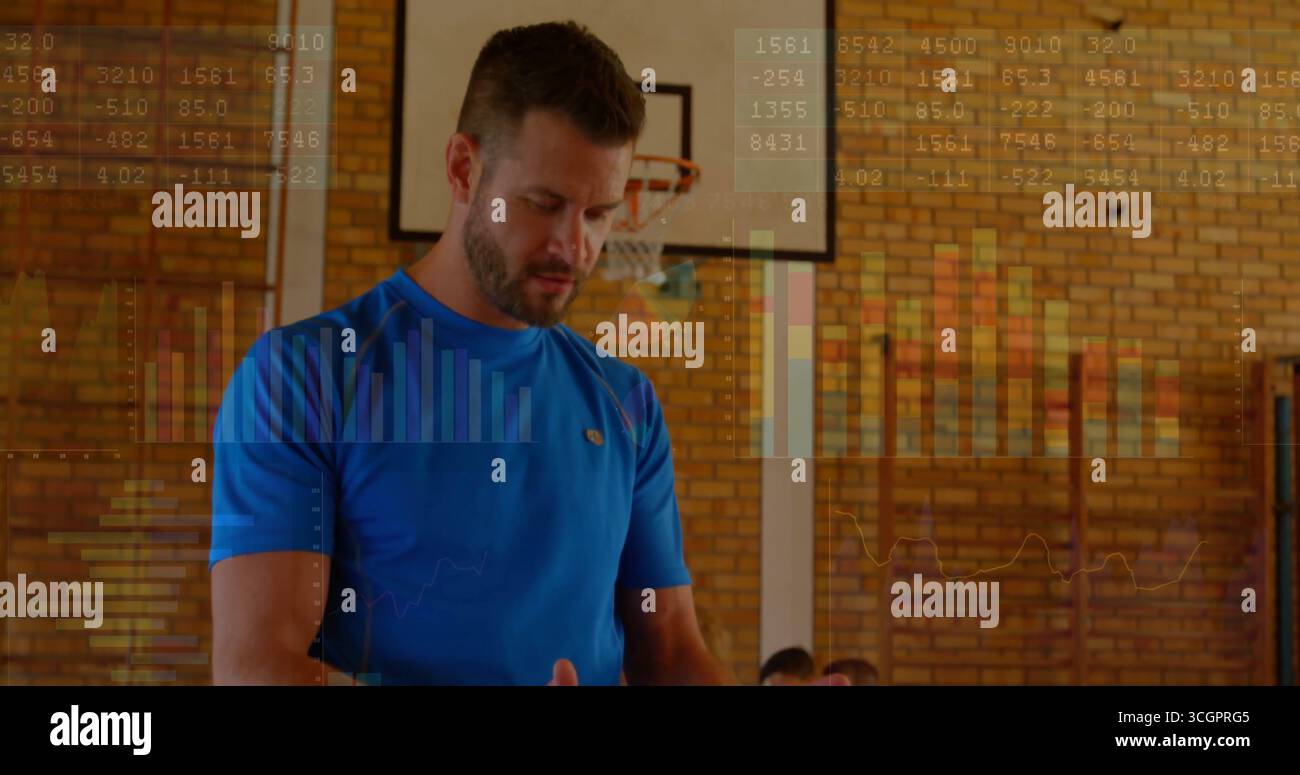Allenatore che indossa una camicia blu che guida il tirocinante in palestra, con canestro da basket, barre per arrampicata e panca Foto Stock