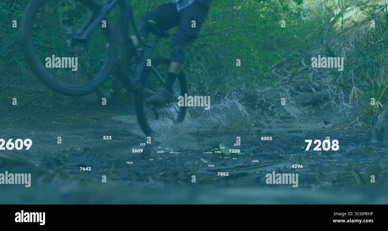 Motociclista che indossa pantaloncini corti e camicia blu che spruzza attraverso il ruscello poco profondo della foresta, spruzzi d'acqua Foto Stock