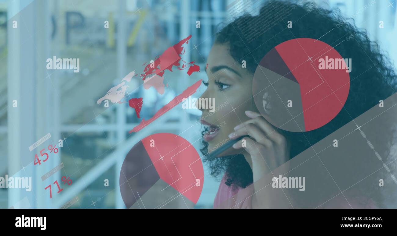 Donna d'affari parlante con una camicetta rosa che tiene lo smartphone in ufficio, con sovrapposizioni cartografiche e mappe Foto Stock