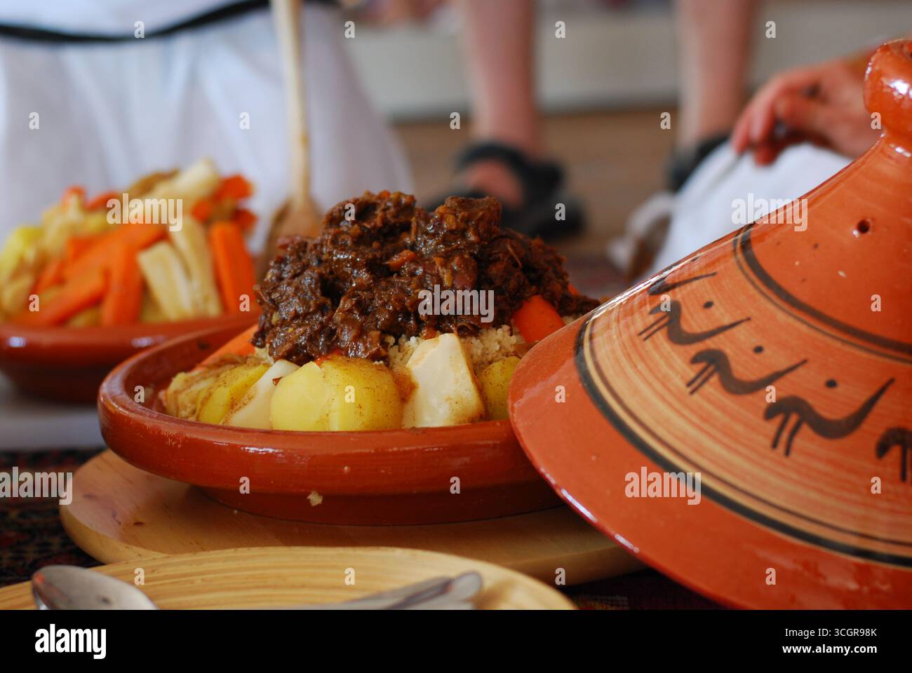 Piatti tradizionali marocchini serviti con tagine e tè. Cucina autentica con piatti aromatici e un'atmosfera culturale. Foto Stock