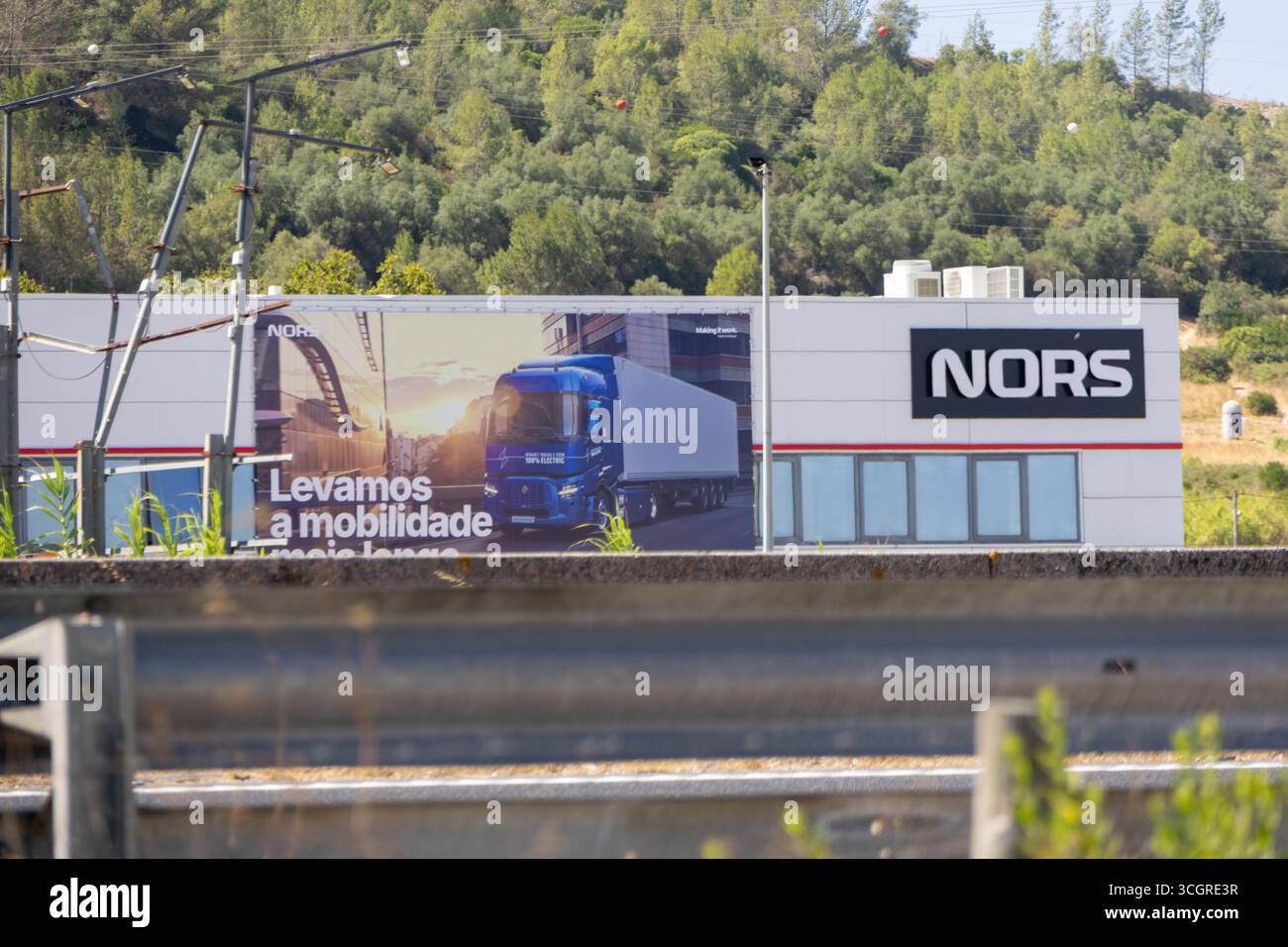 Edificio Nors con grande cartellone pubblicitario con veicoli renault in portogallo, che promuove soluzioni di mobilità e trasporto Foto Stock