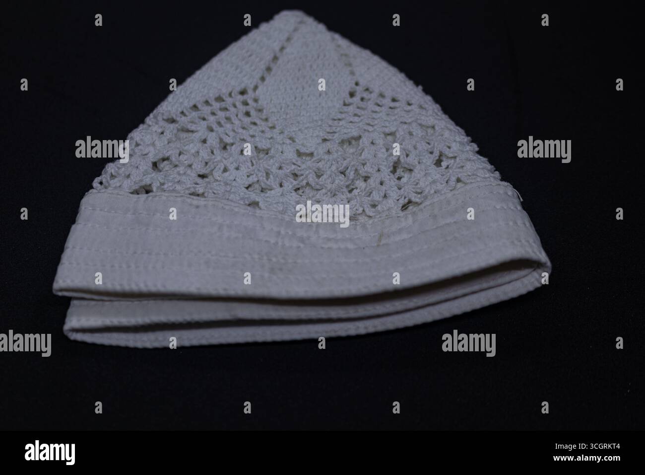 Berretto islamico lavorato a maglia per sfondo nero salato Foto Stock
