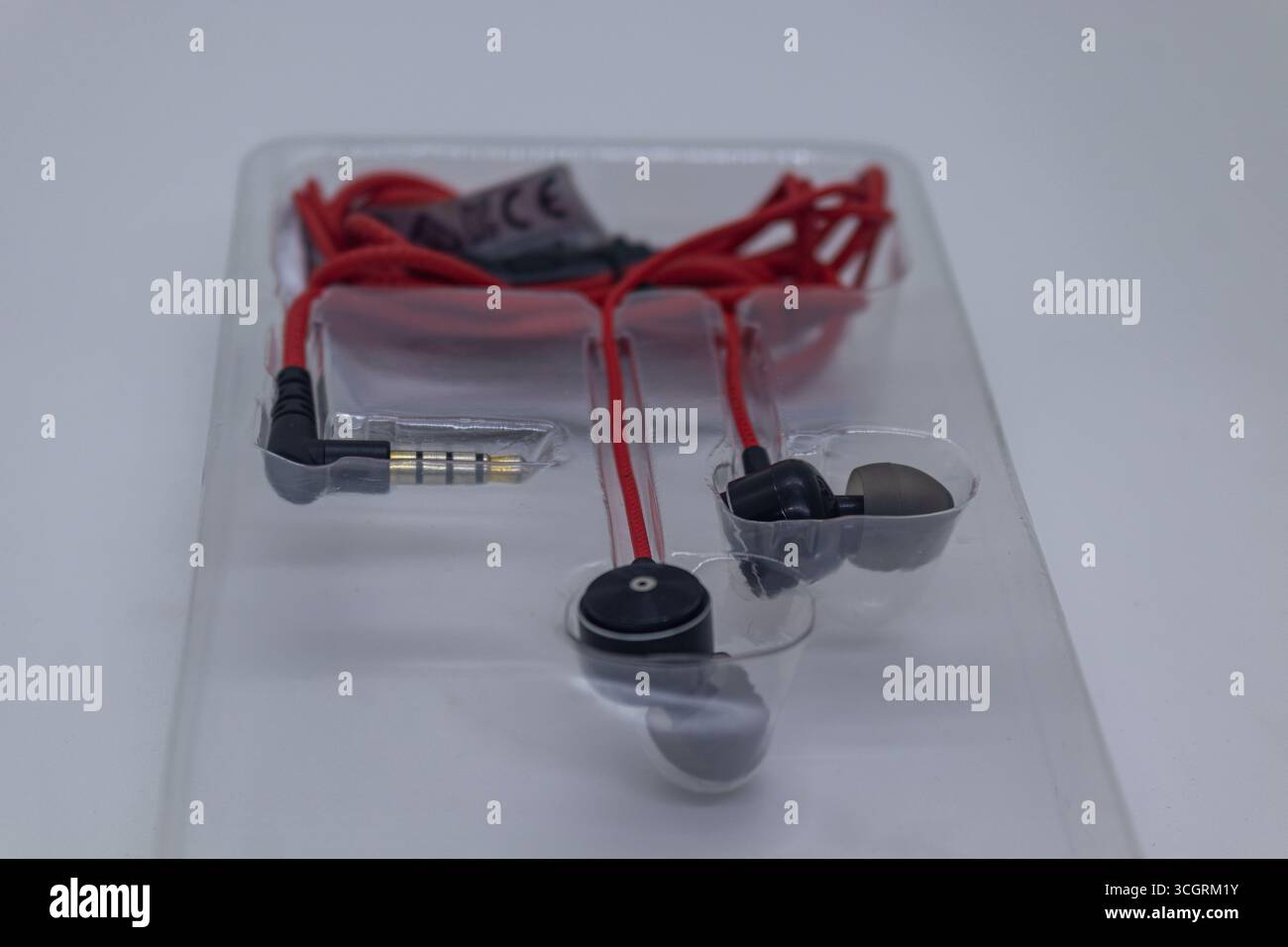 Auricolari rossi minimali su sfondo bianco isolato Foto Stock