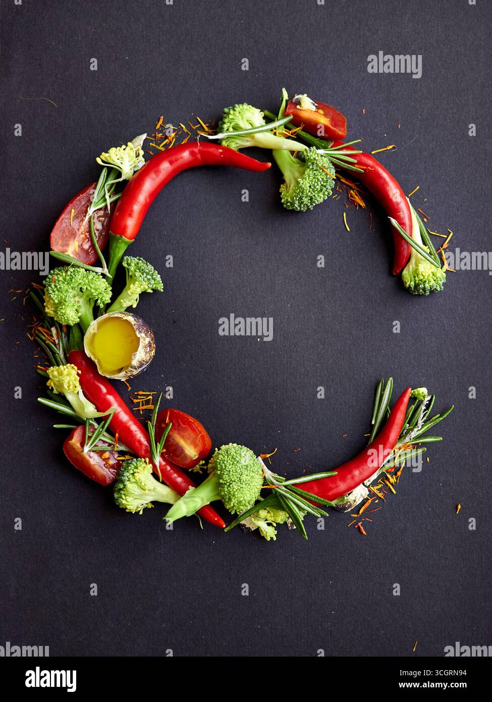 Lettera creativa C formata da peperoncino, broccoli, rosmarino, pomodoro e olio d'oliva su sfondo scuro. Tipografia alimentare unica per un'alimentazione sana, r Foto Stock