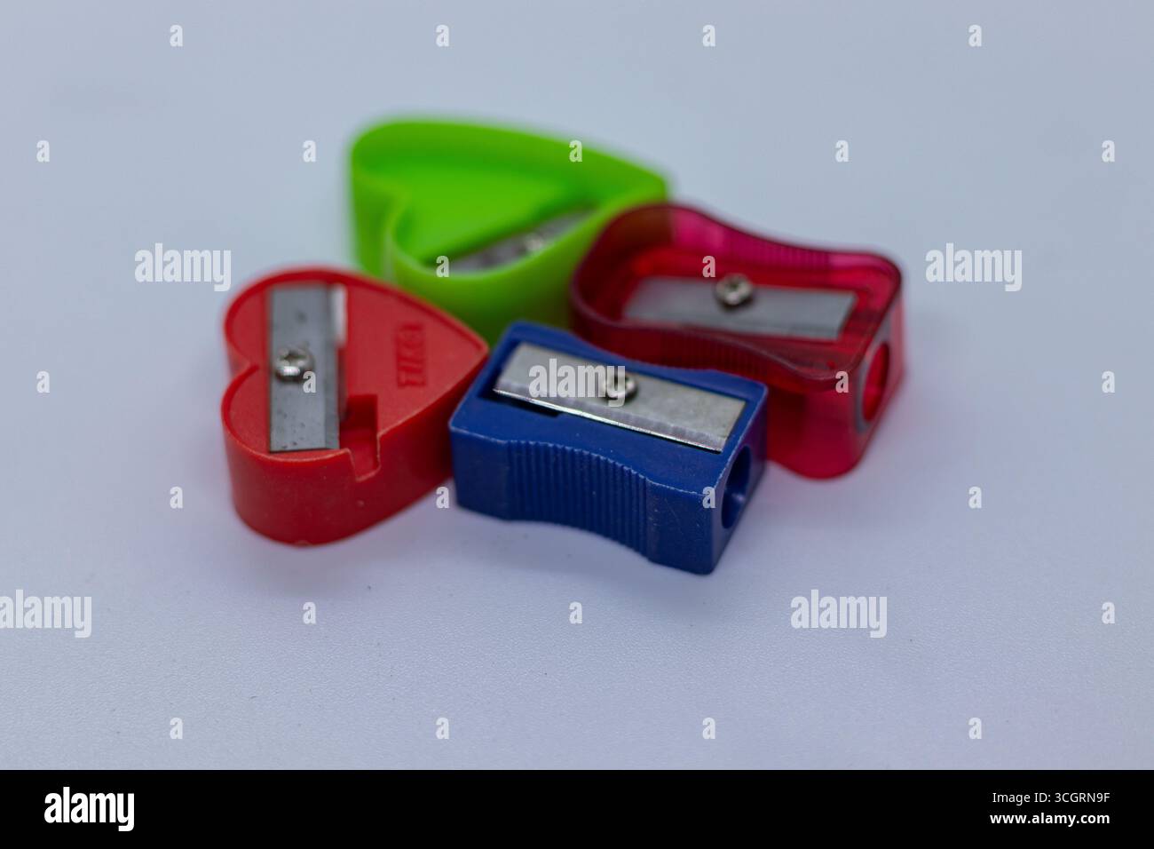 Set di strumenti di affilatura a matita a colori misti per la raccolta di cancelleria su sfondo neutro Foto Stock