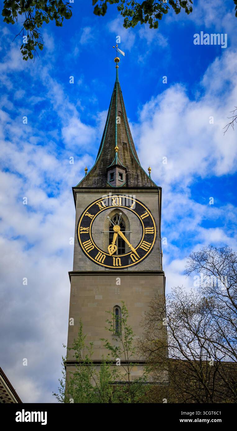 L'iconica chiesa di San Pietro, uno storico edificio barocco con il più grande orologio della chiesa d'Europa, sotto uno splendido cielo blu a Zurigo, in Svizzera Foto Stock