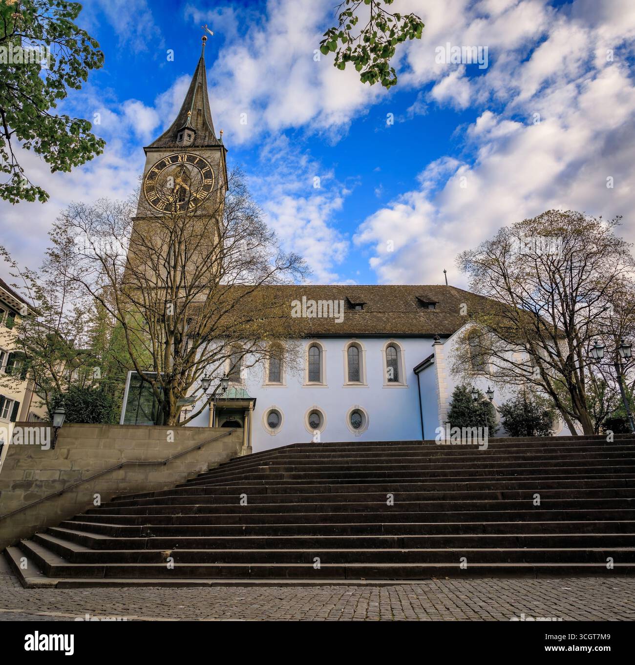 L'iconica chiesa di San Pietro, uno storico edificio barocco con il più grande orologio della chiesa d'Europa, sotto uno splendido cielo blu a Zurigo, in Svizzera Foto Stock