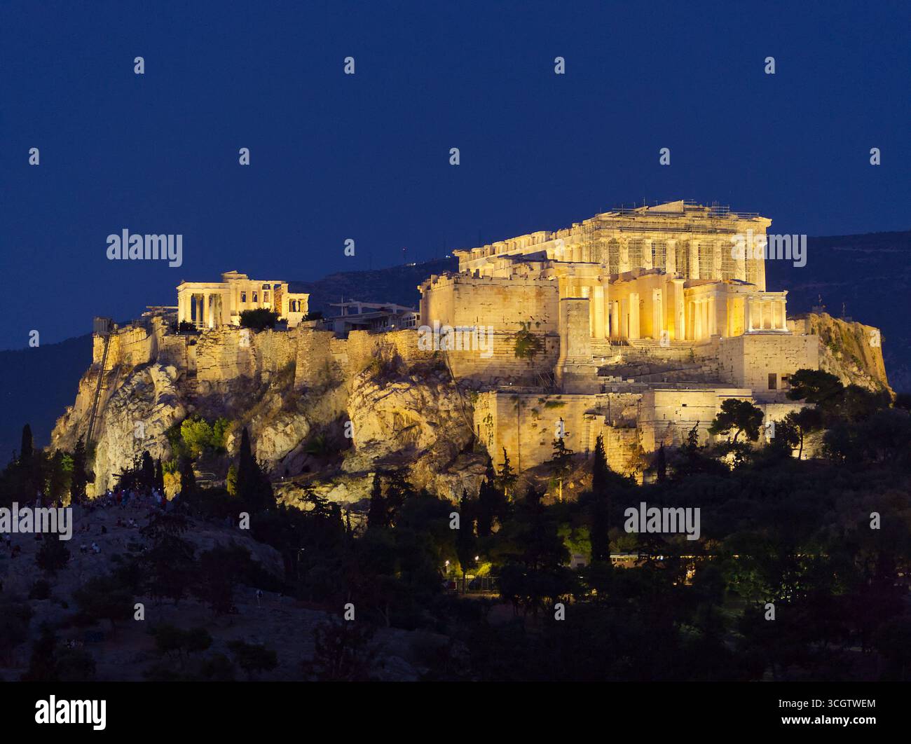 L'Acropoli di Atene si illuminò di notte, mostrando l'antico Partenone in cima a una collina rocciosa Foto Stock