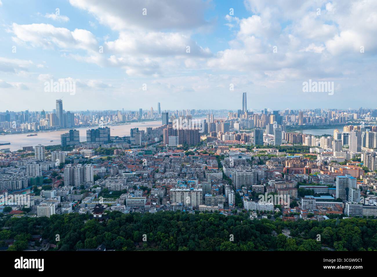Lo skyline della città di Wuhan si estende lungo il fiume Yangtze, mostrando un'architettura moderna e un vasto paesaggio urbano sotto un cielo parzialmente nuvoloso. Foto Stock