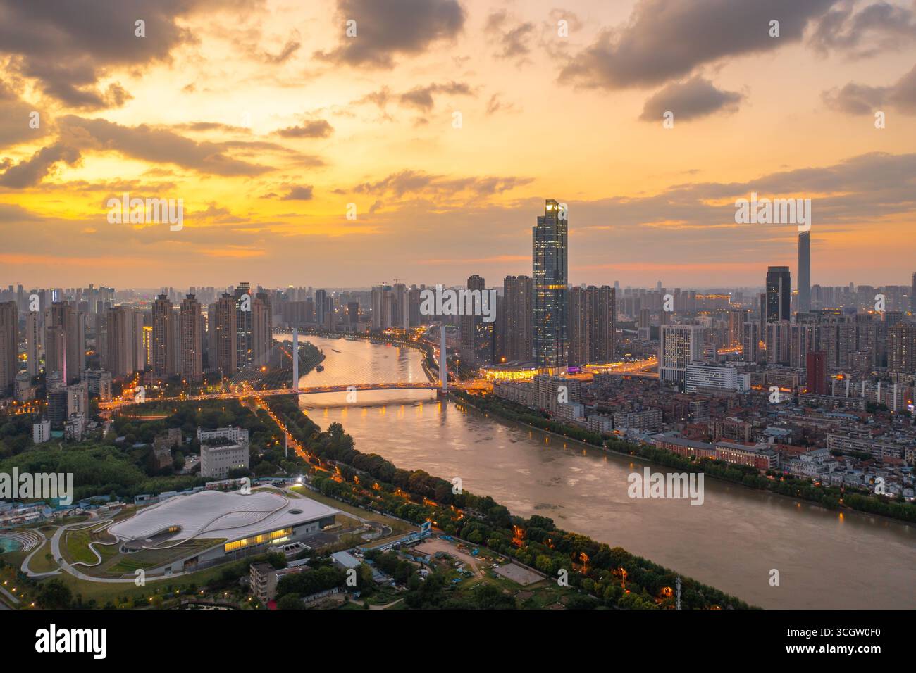 Tramonto sullo skyline della città di Wuhan con il fiume Yangtze e le luci del ponte. Foto Stock