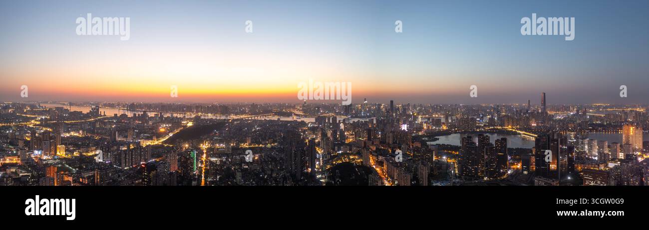 Lo skyline di Wuhan mostra il fiume Yangtze al crepuscolo con luci accese. Foto Stock