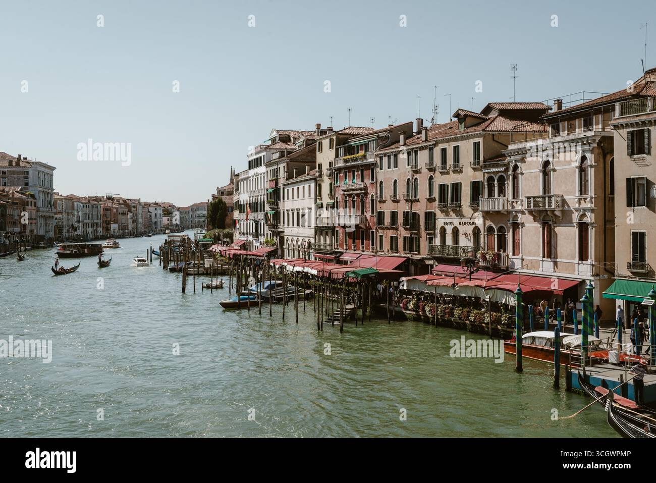 Venezia, Italia - 25 settembre 2023: Vista panoramica del Canal grande con gondole e ristoranti sul lungomare lungo edifici storici Foto Stock Venezia, Italia - 25 settembre 2023: Vista panoramica del Canal grande con gondole e ristoranti sul lungomare lungo edifici storici Foto Stock