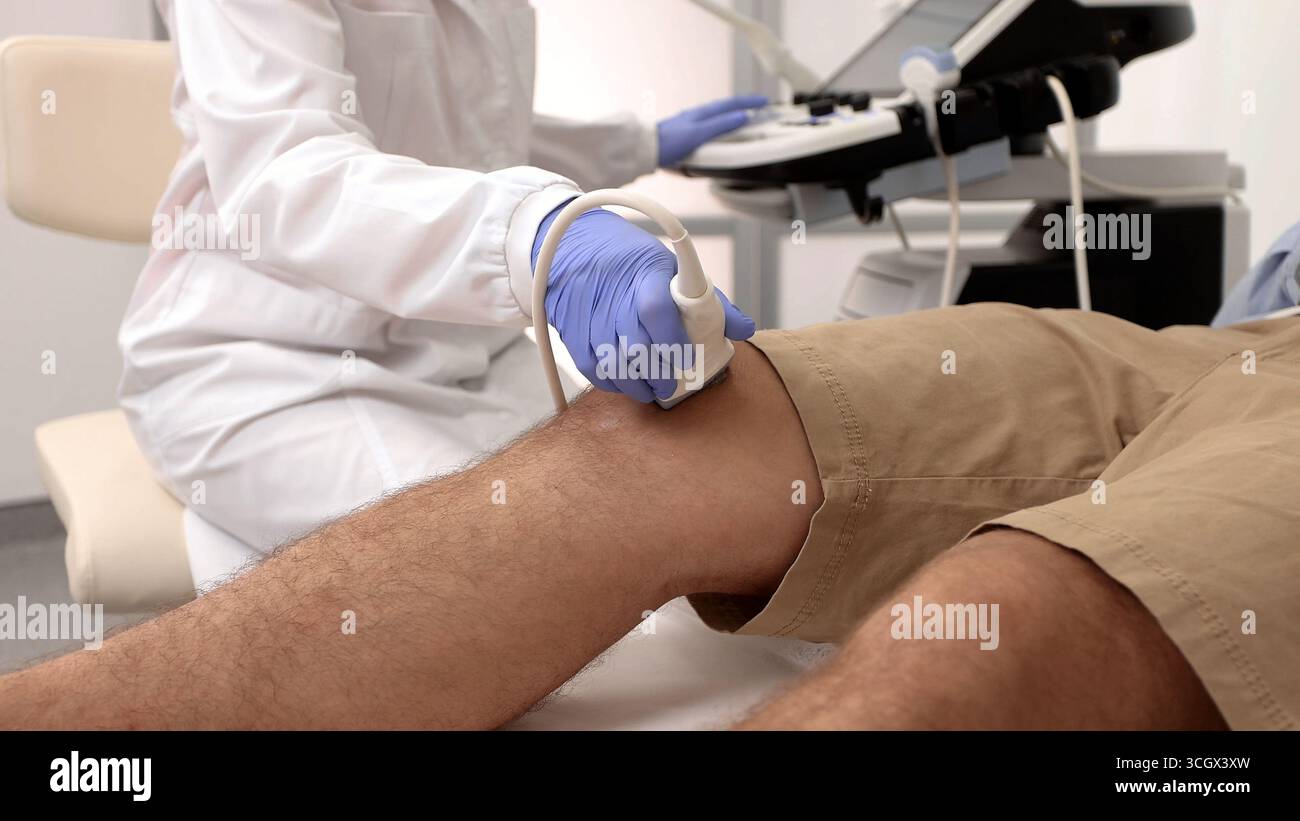 Trattamento per lesioni al ginocchio. Esame ecografico del ginocchio Foto Stock