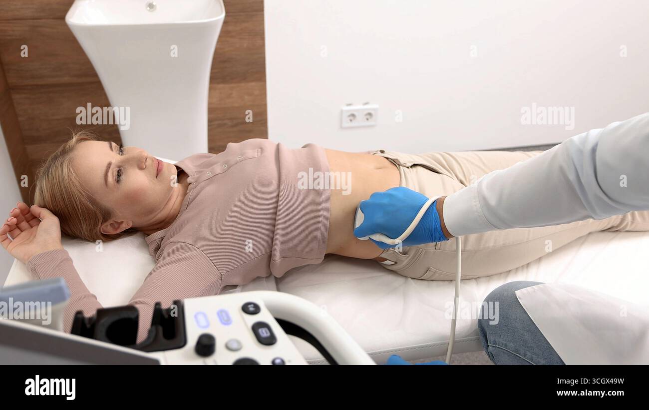 Ecografia dei reni. Paziente donna durante l'esame ecografico in clinica medica sdraiata sulla schiena. Ecografia dei reni Foto Stock